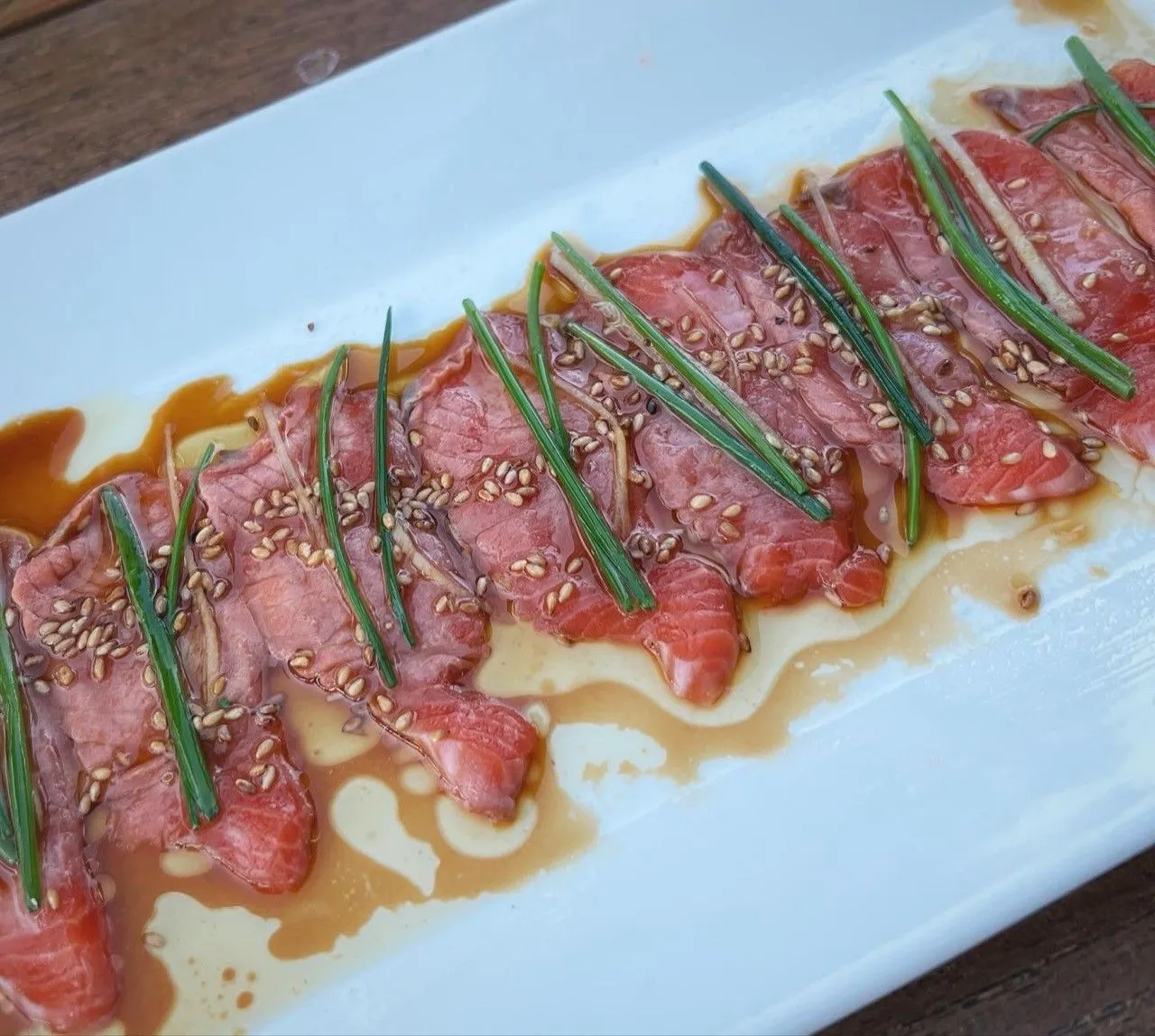Sliced fish with sesame seeds and chives at Matsuhisa in Aspen